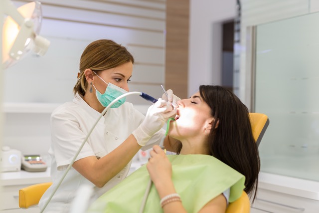 Woman recieving a filling at the dentist office